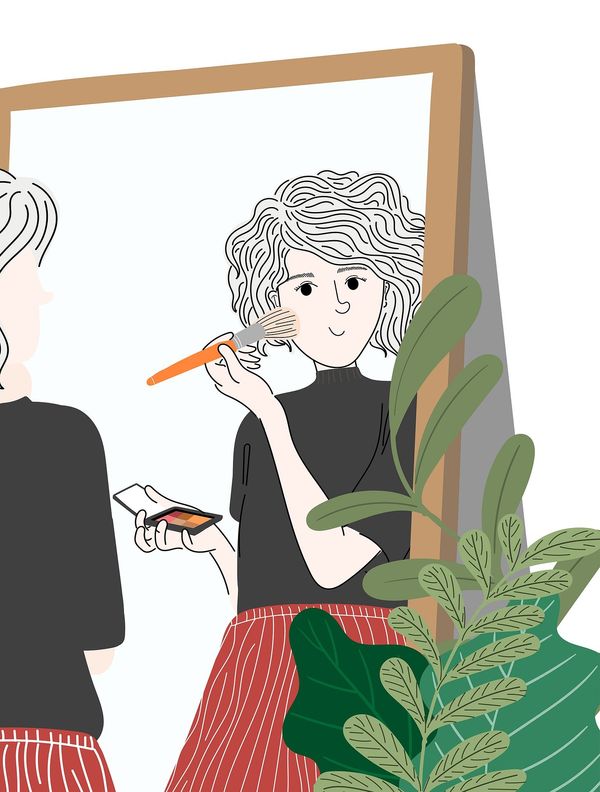 An illustration of a woman applying makeup to her face while standing in front of a full-length mirror. There is a house plant beside the mirror.
