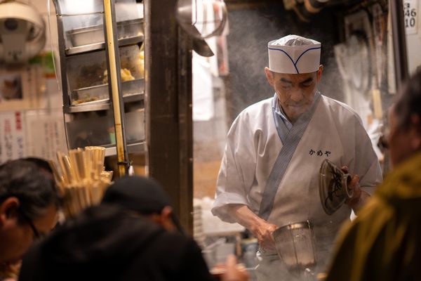 A chef working among rising steam in a kitchen in Japan.