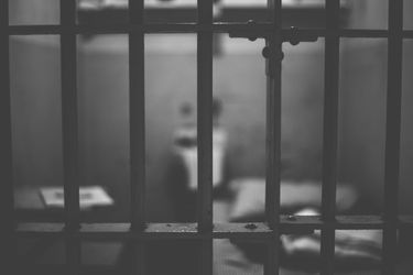 A jail cell behind bars.
