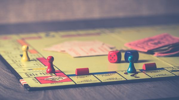 The board game Monopoly with tokens, die, cards, and paper money.