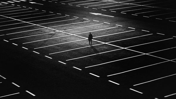 A personal alone in a large car park.