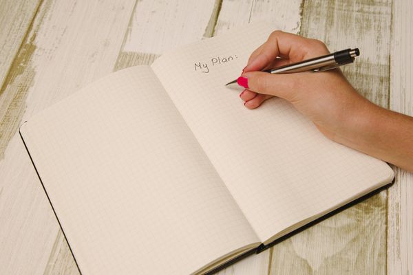 A hand holding a pen and writing in a notebook. The title is 'My Plan'.