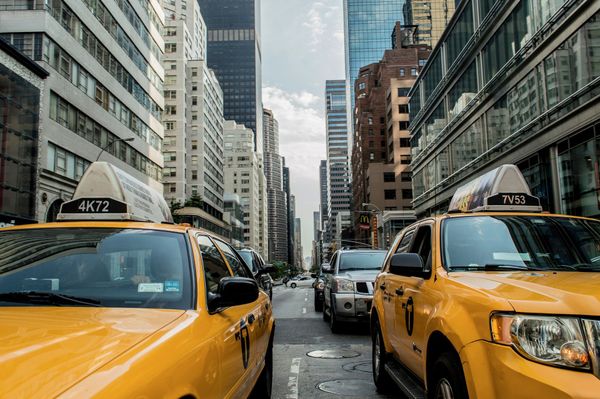 The view down a long Manhattan street with yellow taxis in the foreground.