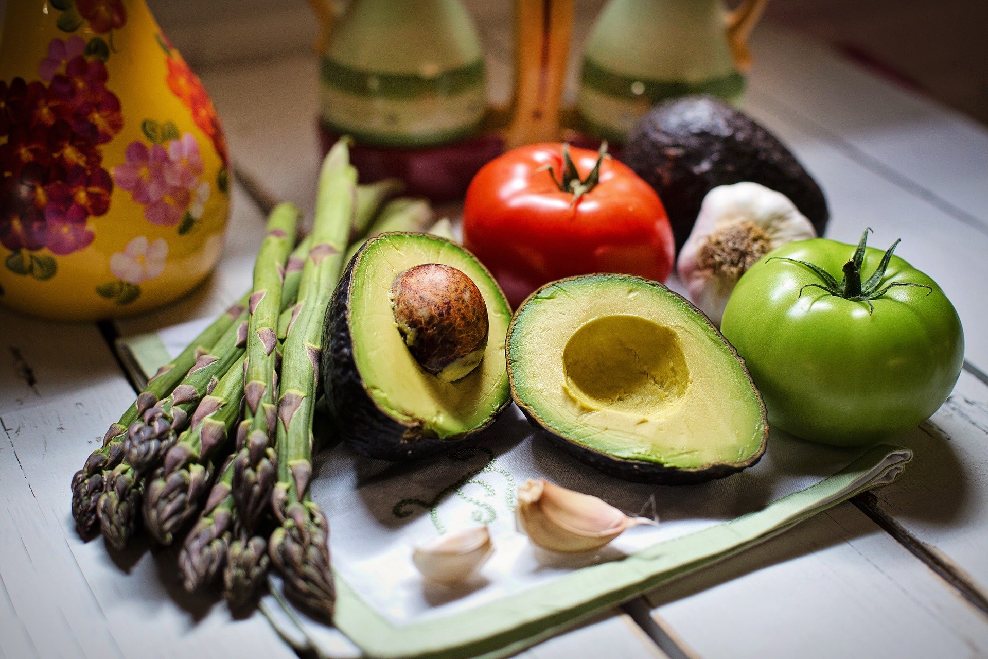 asparagus, a halved avocado, tomatoes, and garlic
